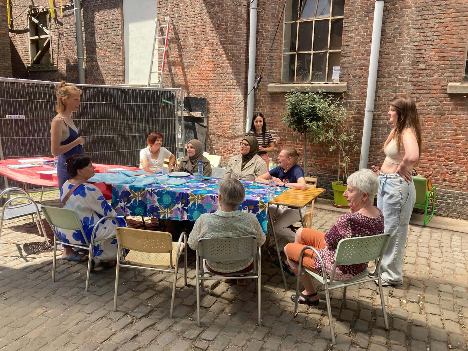 Bezoekers aan tafel op het binnenplein van maakleerplek